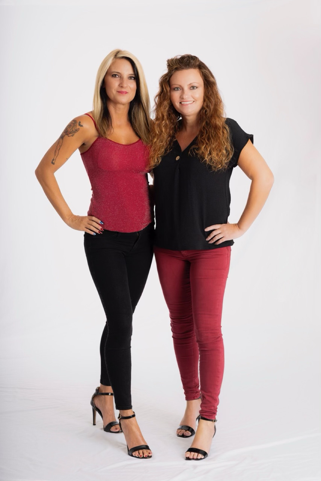 The Sold Sisters — Amber Mouser and her sister — standing together in their signature red and black